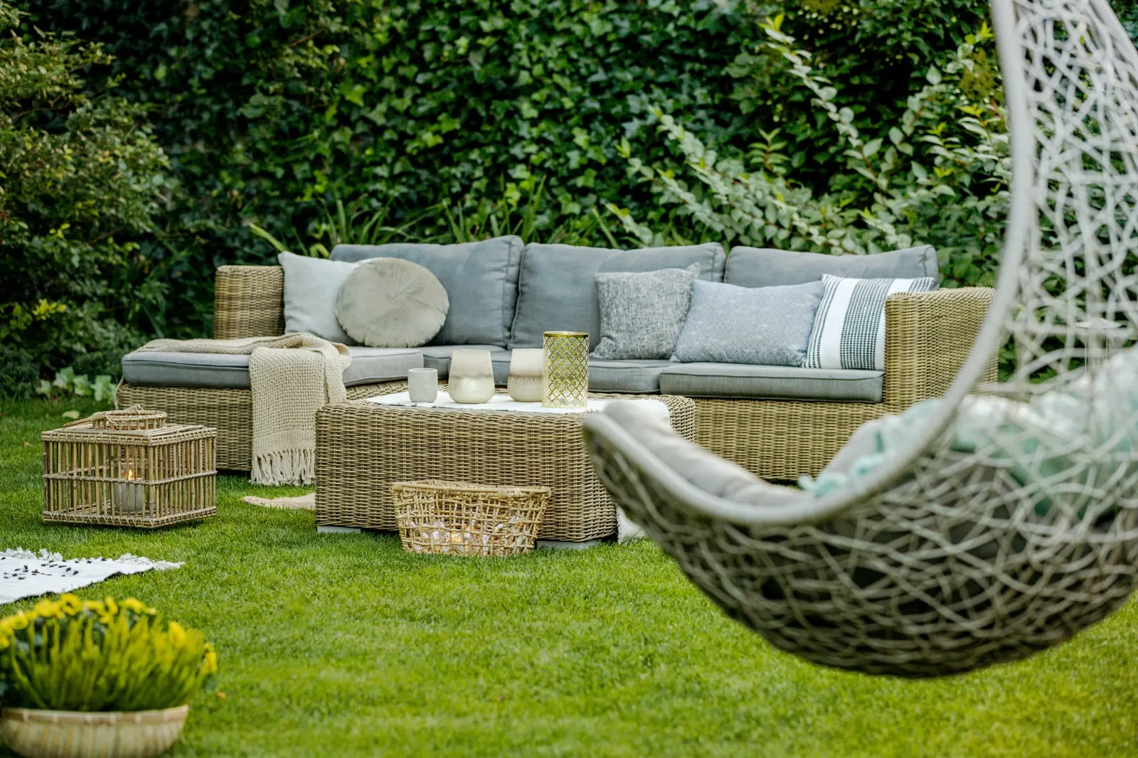 Jardin aménagé avec salon d'extérieur et fauteuil suspendu